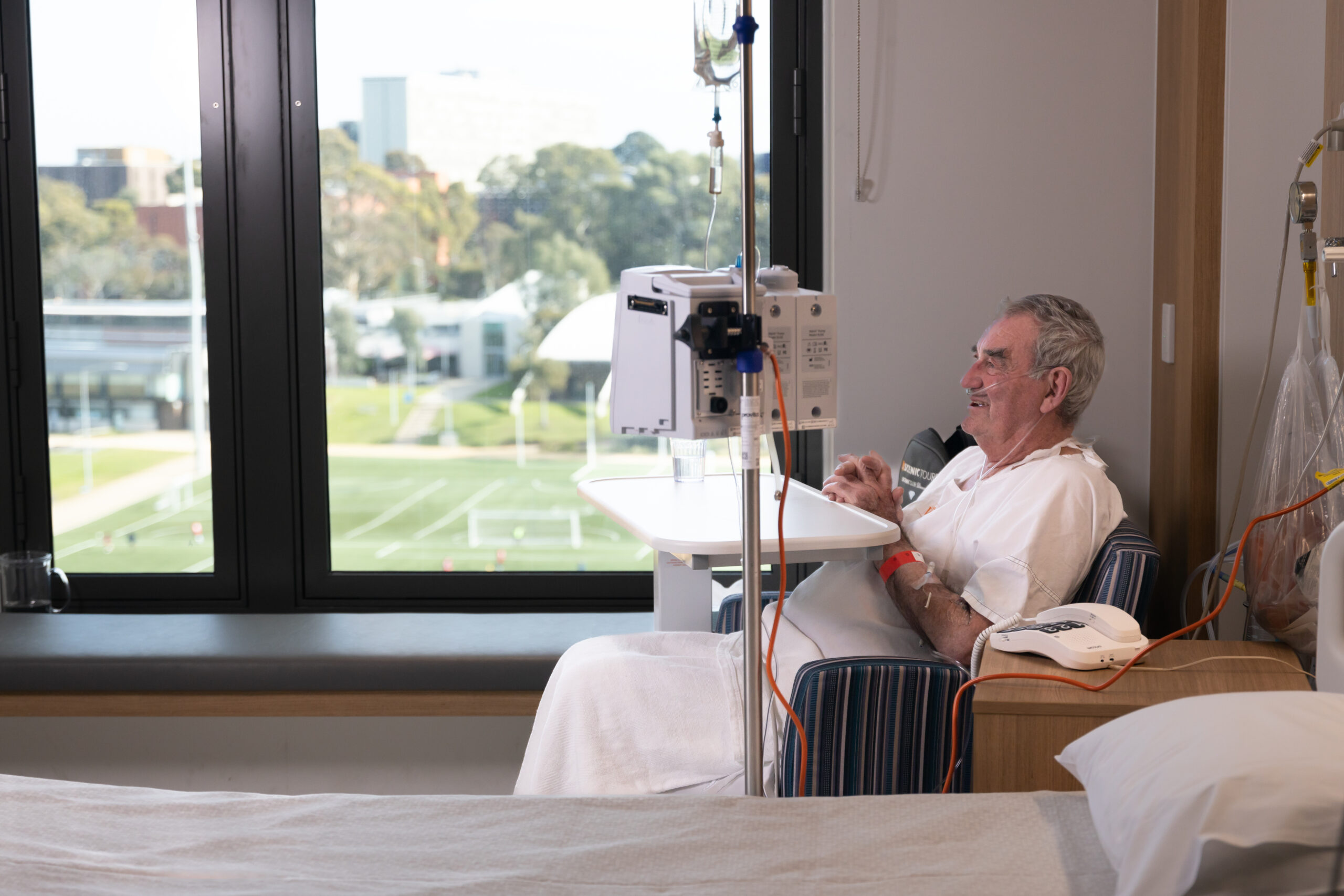 First air ambulance patient John Carmichael sits by the window in his room at the Victorian Heart Hospital.