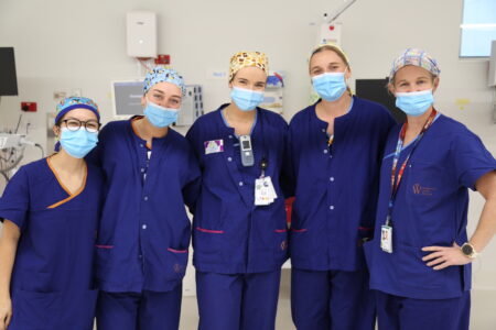 Photo of five clinical employees wearing their colourful cloth hats in the ward
