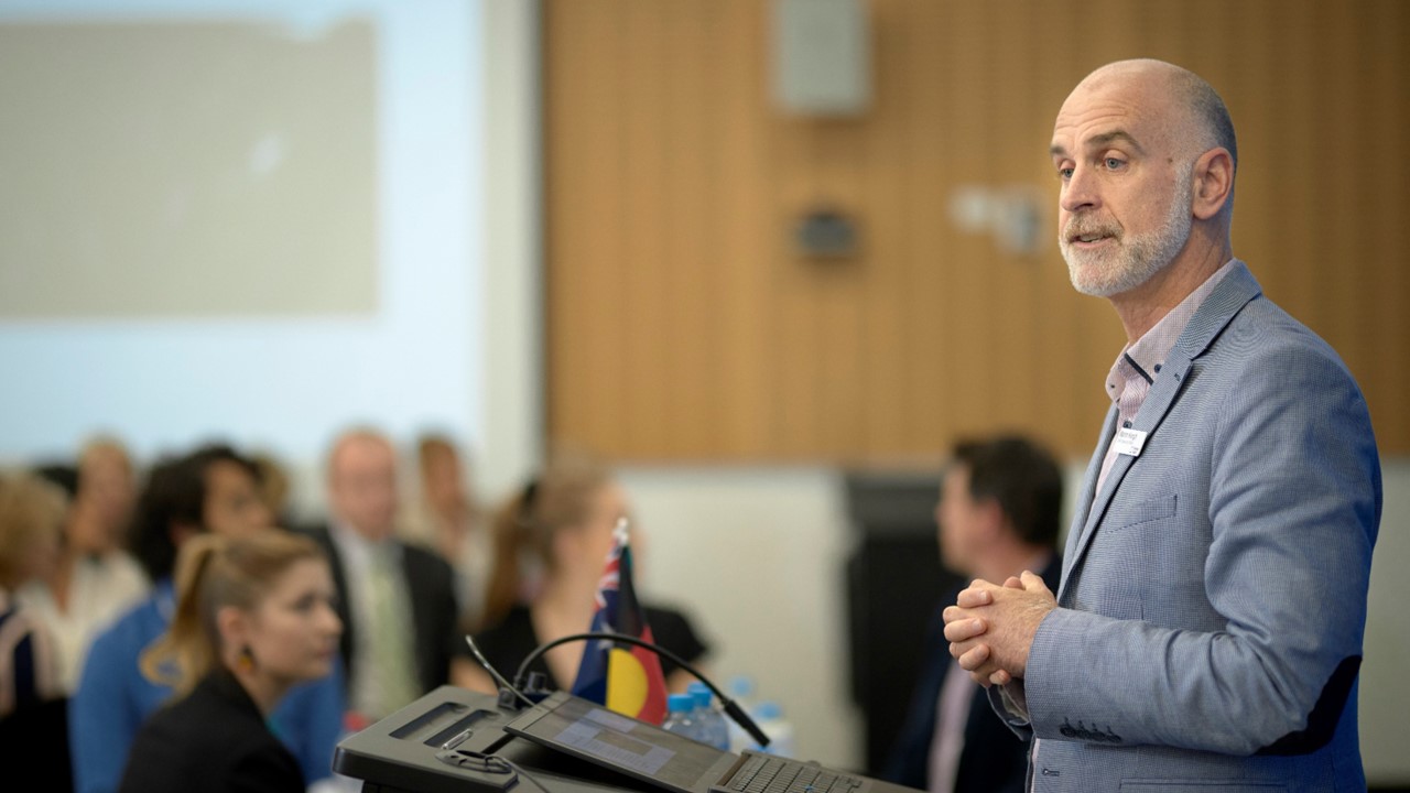 Acting Chief Executive, Martin Keogh, standing at a lectern addressing a room of people
