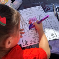 A girl colours in a dragon colouring sheet. A girl colours in a dragon colouring sheet.