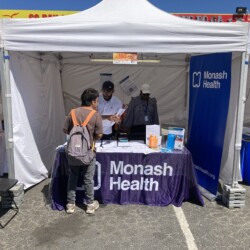 Members of the South East Public Health Unit talk to a man at the Monash Health stall at Springvale Lunar New Year Festival. Members of the South East Public Health Unit talk to a man at the Monash Health stall.